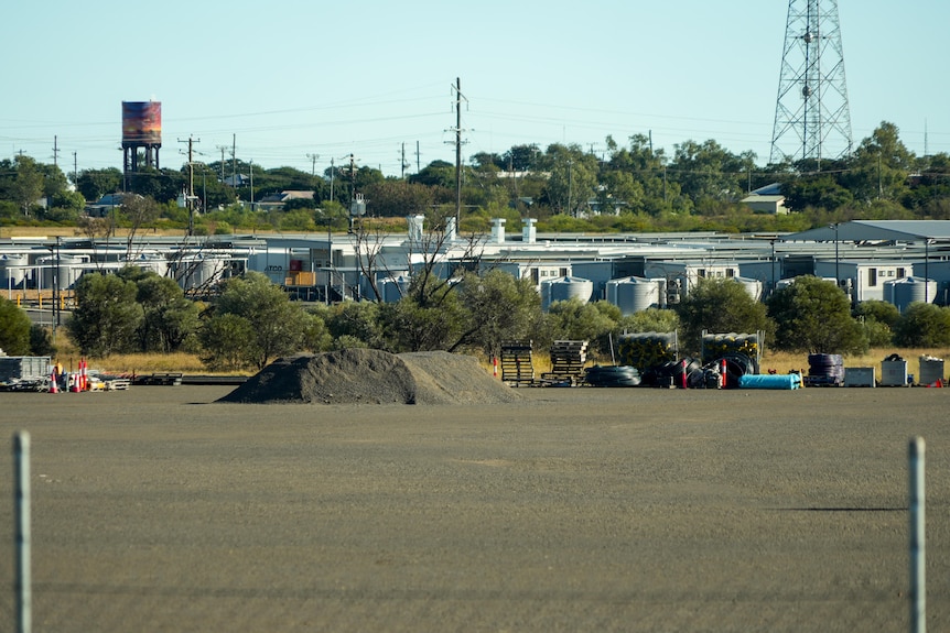 A work camp and construction site with fence in foreground