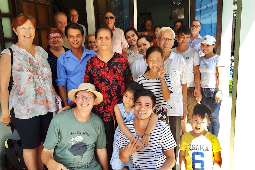 Jerry Coleby-Williams and Thuan squat at the front of a big family group