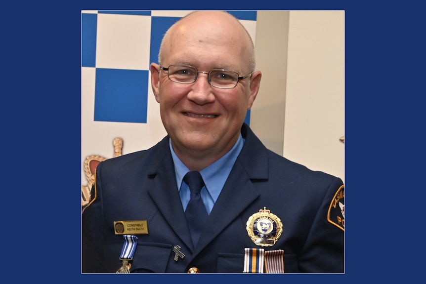 A bald man in police uniform.