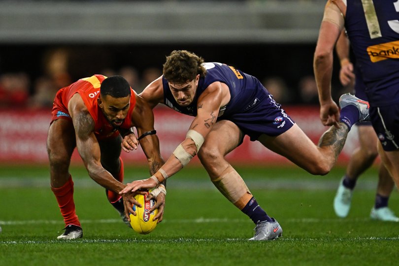 Touk Miller of the Suns competes for the ball with Luke Jackson.