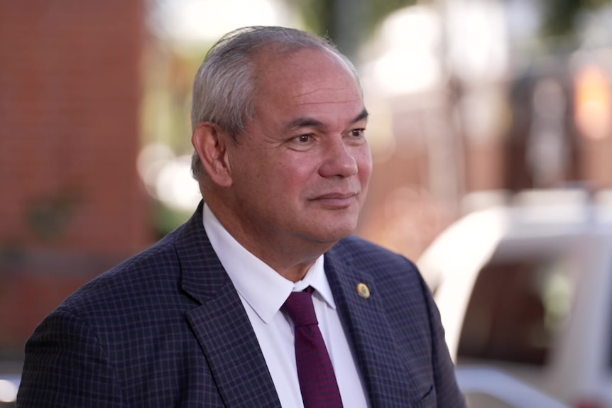 Man in suit looks off to the side