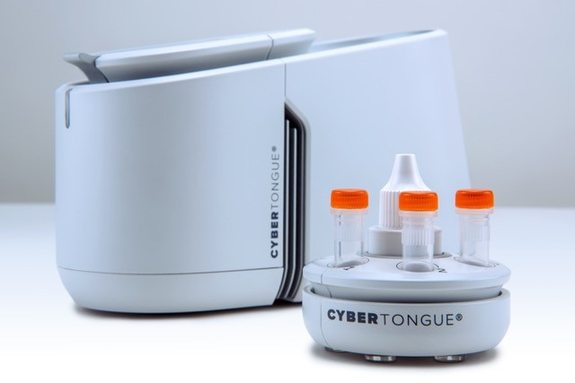 A sleek white machine with the word "cybertongue" printed on it and small plastic pipettes next to it.