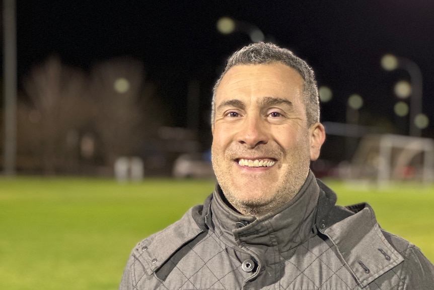 Close up image of a person wearing jacket in a soccer ground