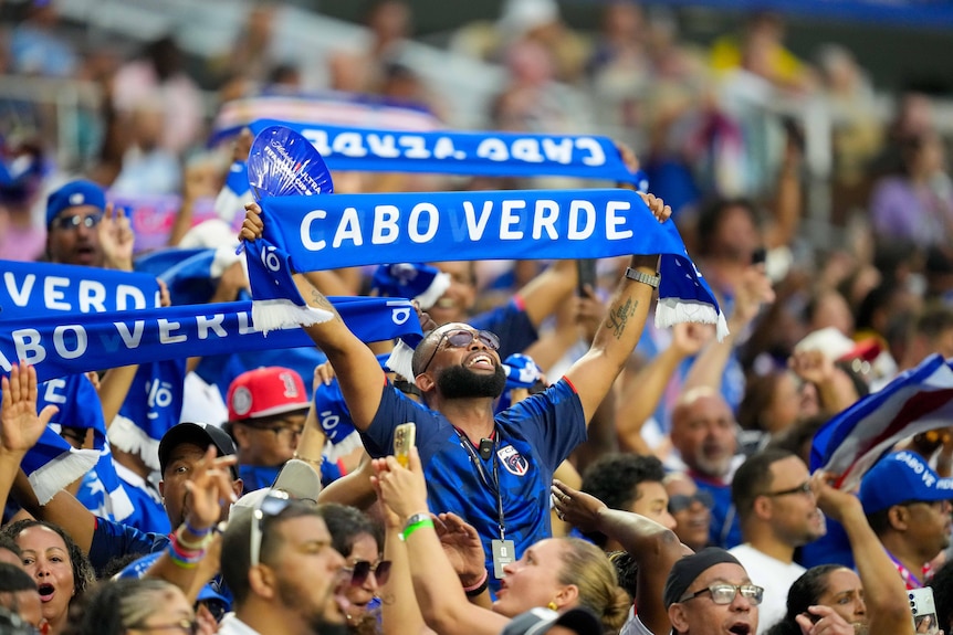 Cabo Verde supporters hold up scarves.