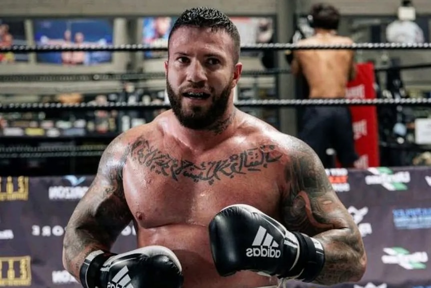 Sam Abdulrahim standing in a gym with boxing gloves on.