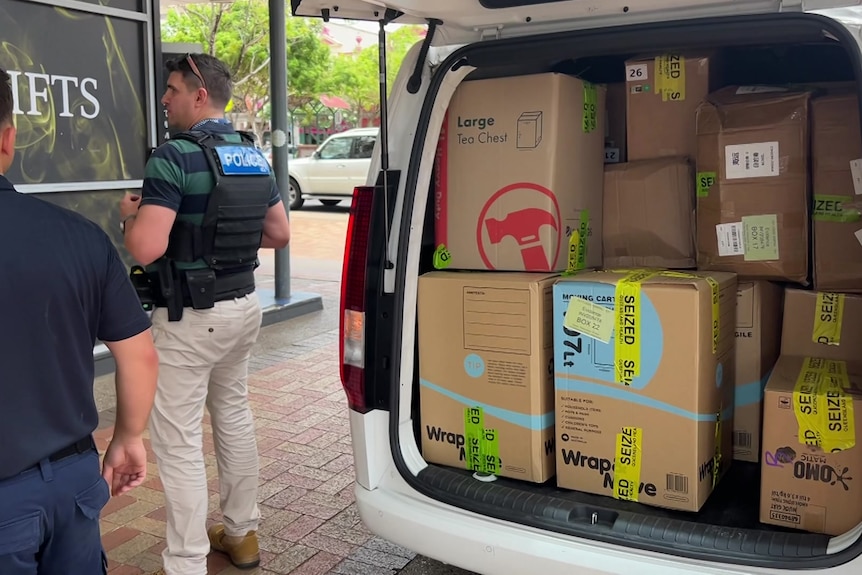 Moving boxes with yellow tape and the word seized.