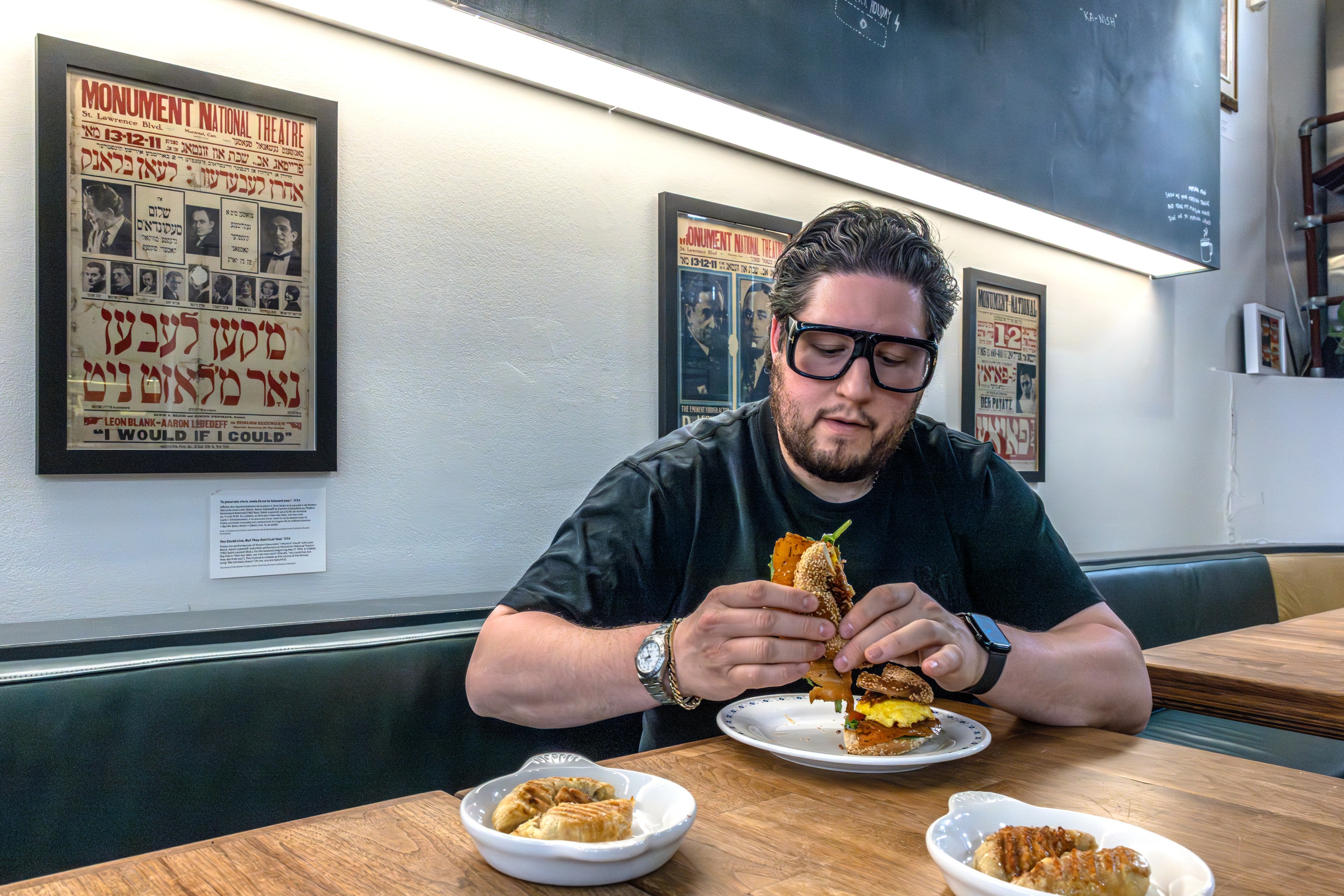 Guy sitting at table in restaurant, eating.