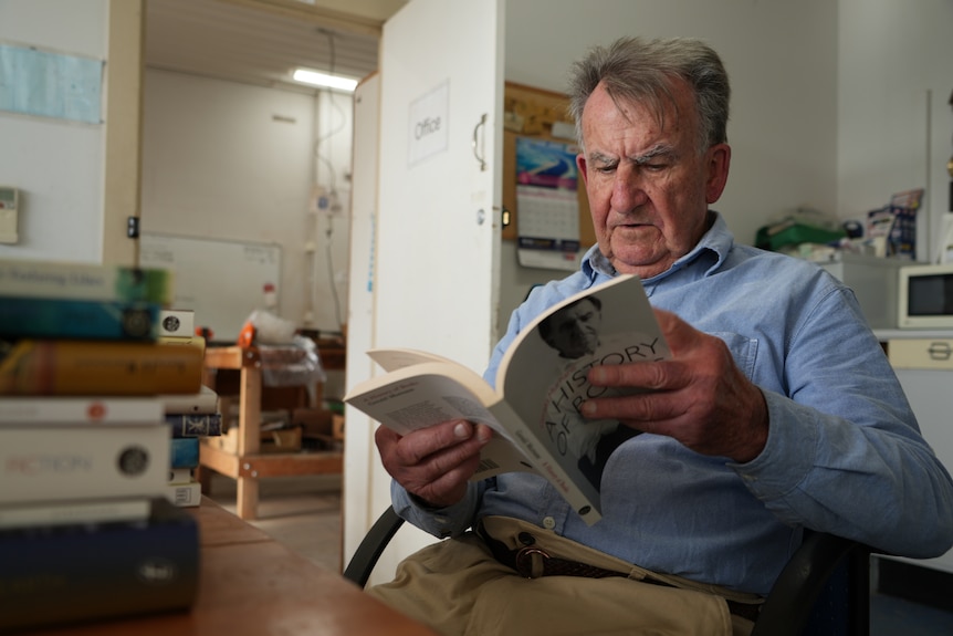 An author looks at a book.