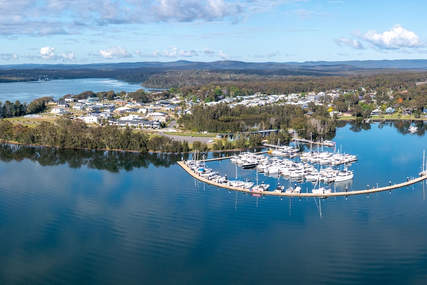 Aerial view of boats stored on a harbour with a city as a backdrop.
