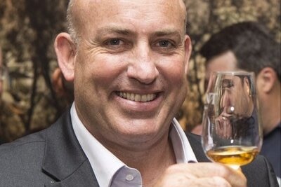 Keith Batt holds a glass of liquor.