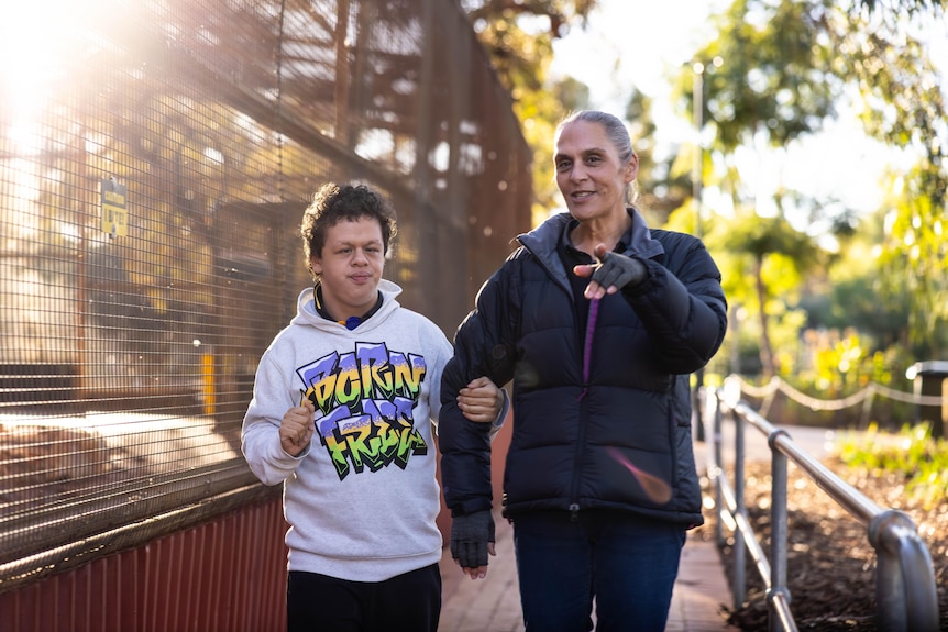 Mother and son walking together in park