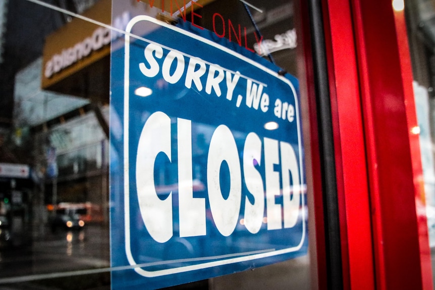 A closed sign hangs on a glass door.