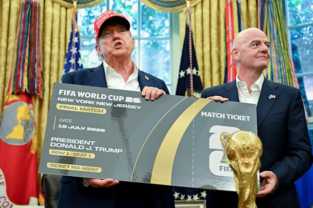 US president Donald Trump and FIFA president Gianni Infantino display the ceremonial first ticket for the 2026 World Cup final.