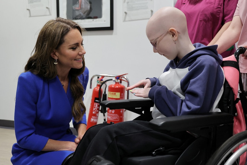 Princess of Wales talking to a young cancer patient who is in a wheelchair