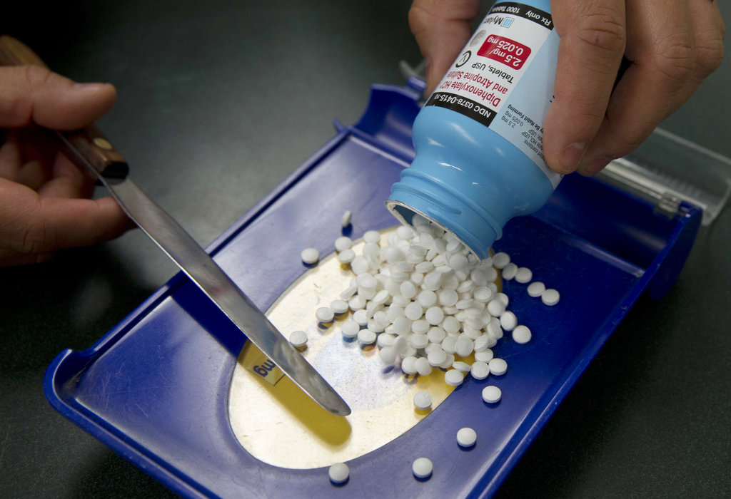 Pills empties onto a tray from a bottle