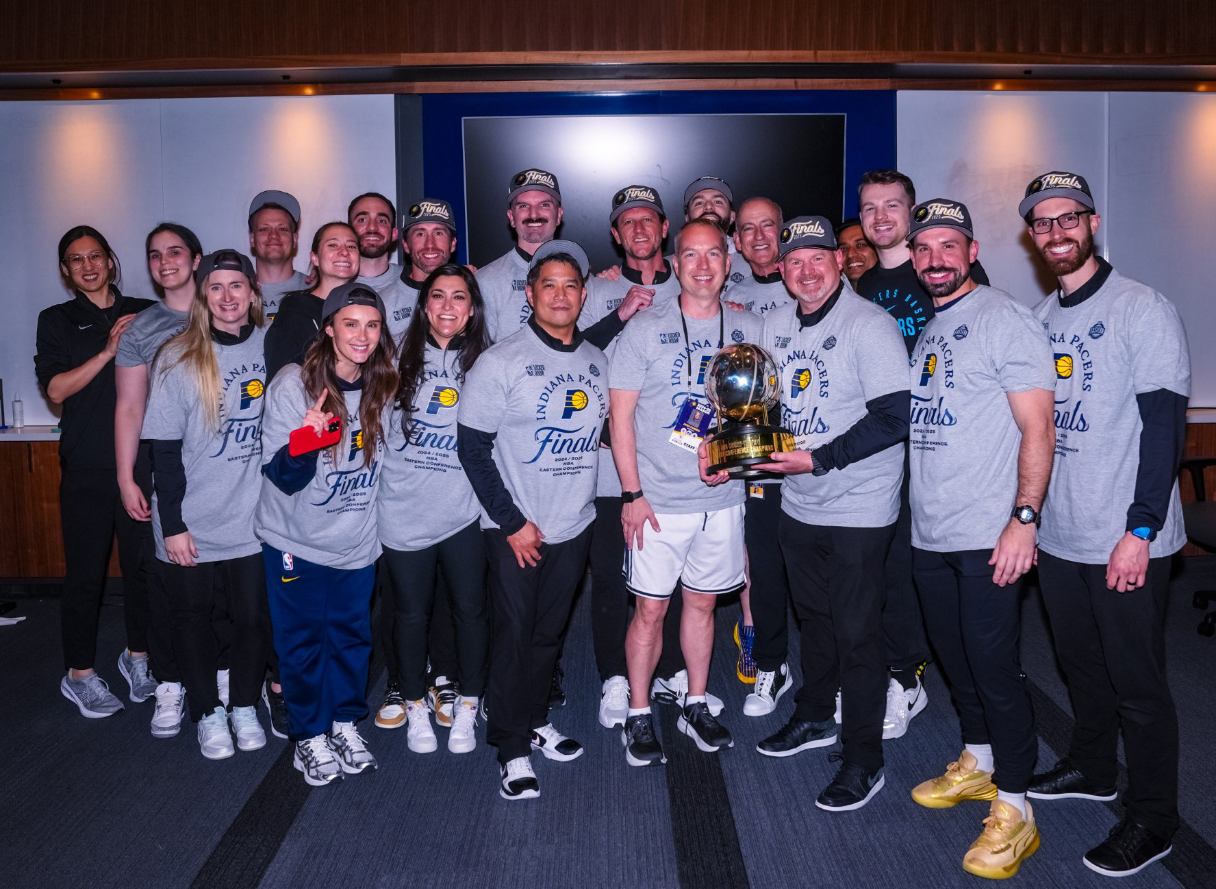 Indiana Pacers staff pose with the Eastern Conference championship trophy.