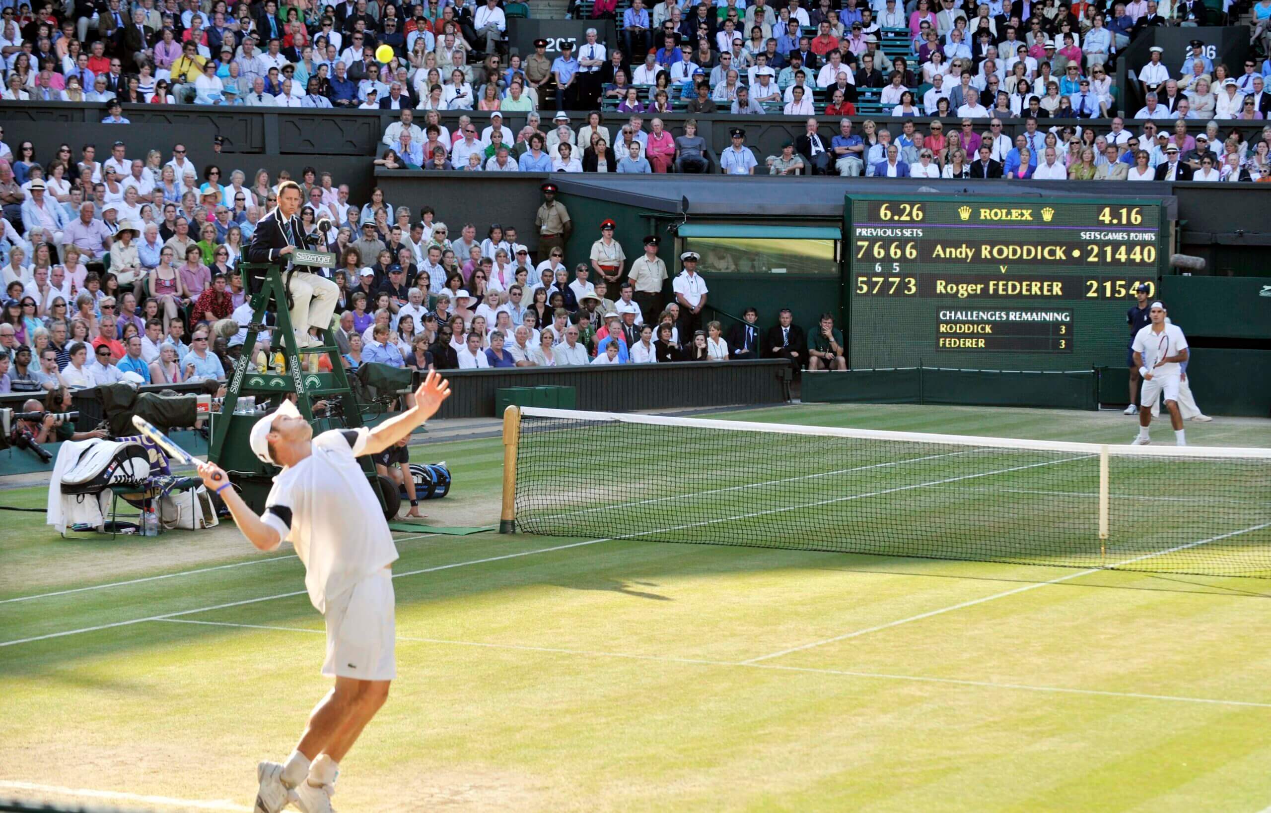 Andy Roddick prepares to hit a serve on Centre Court at Wimbledon with Roger Federer at the other end The scoreboard shows it is 15-14 to Federer in the fifth set.