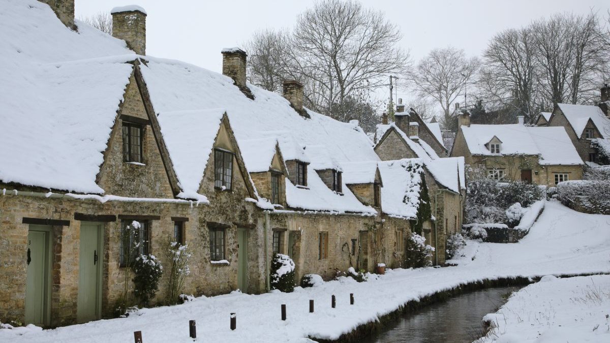 Snow covering Arlington Row in the Cotswolds village of Bibury. - stock photo