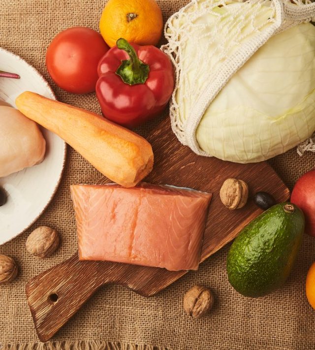 Low carb, FODMAP diet food background with vegetables, fruits, smoked salmon, chicken fillet, greens, nuts, olives. Menu for healthy eating . - stock photo