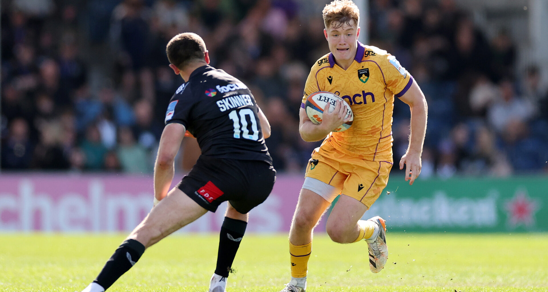 Fin Smith of Northampton Saints takes on Harvey Skinner of Exeter Chiefs during the Gallagher PREM match in April 2026.