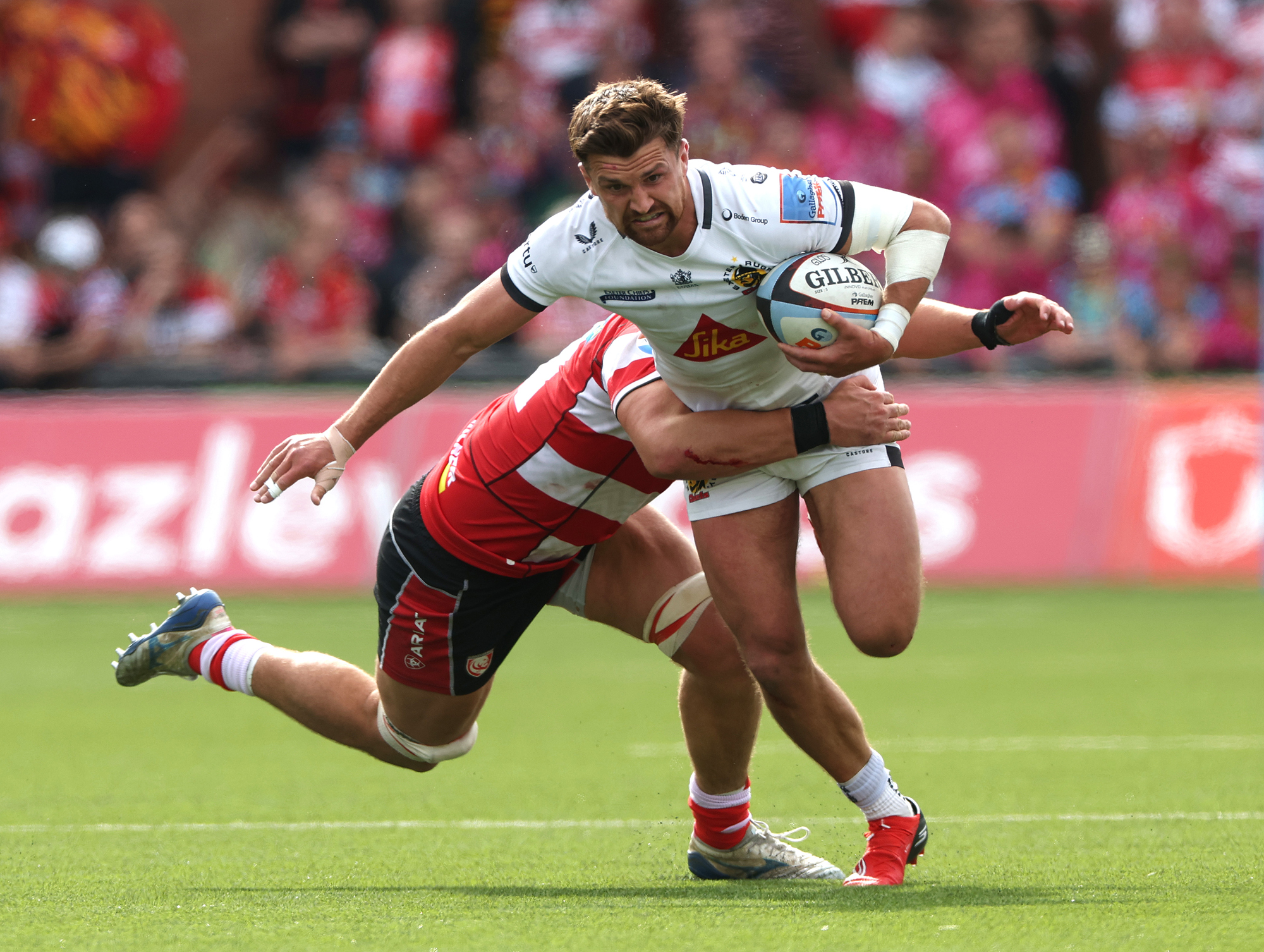 Exeter's Henry Slade is tackled by Gloucester's Freddie Thomas during the April 2026 Gallagher PREM match