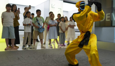 Children watch a martial arts performance by Unitree robots at a humanoid robot store on June 1, 2026 in Zhengzhou, Henan Province of China. The robot is wearing yellow martial arts clothing.