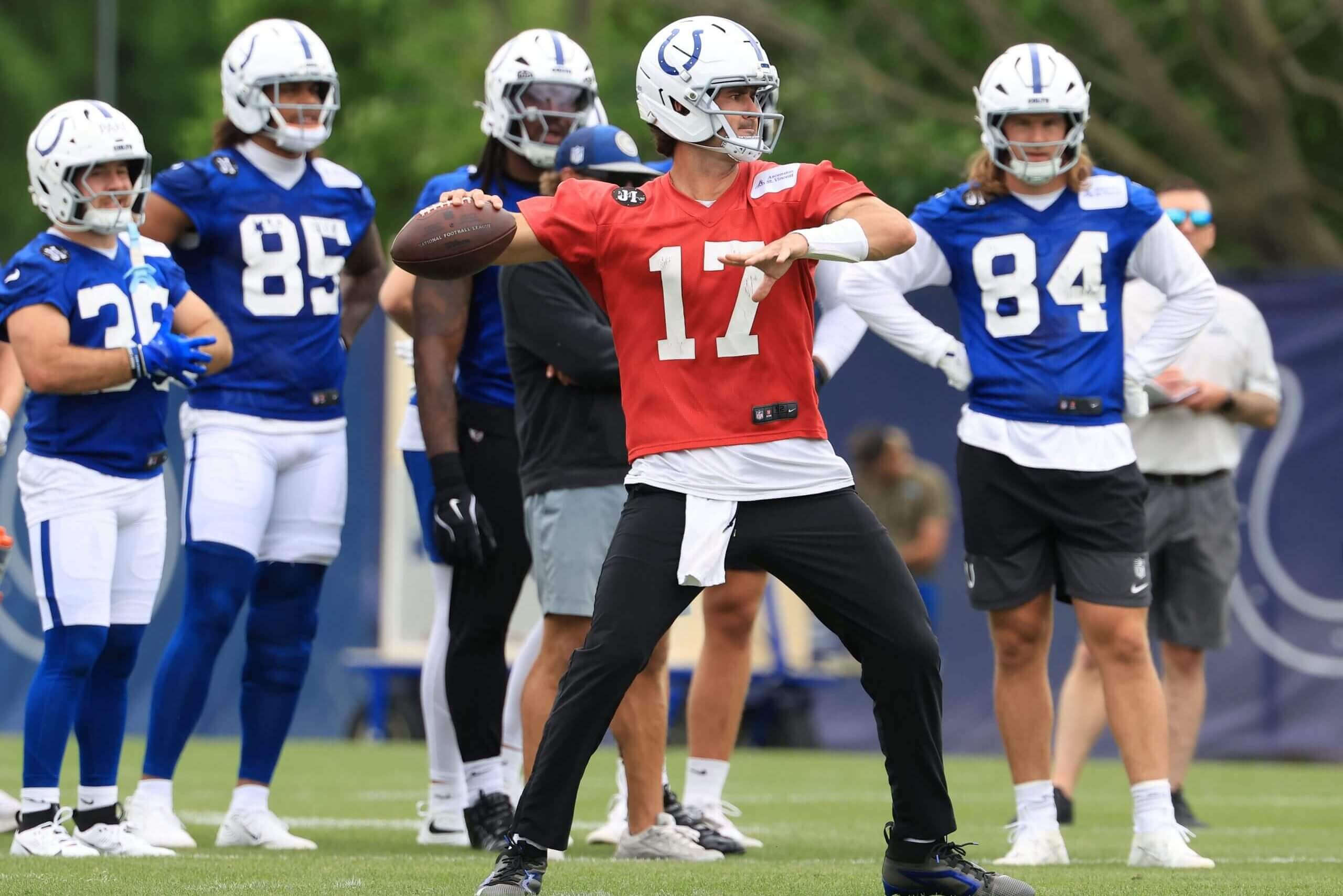 Daniel Jones, in a red #17 jersey, throws a pass during the Indianapolis Colts OTA Offseason Workouts at Indiana Farm Bureau Football Center.
