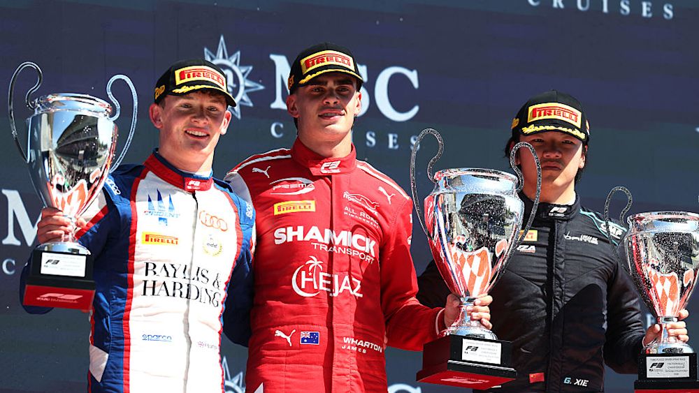 The top three celebrate on the podium at the end of the race