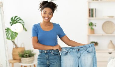 Happy Slim Black Woman Showing Old Oversize Jeans After Successful Weight Loss Diet