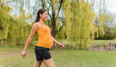 Pregnant woman walking outside in city park during summer for healthy active body workout