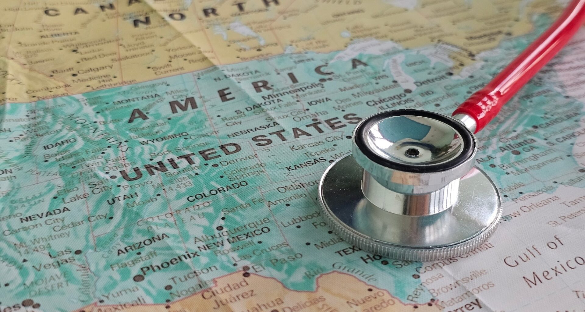 A stethoscope rests on a map of the United States, symbolizing the intersection of healthcare and geographical regions