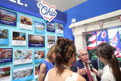 El gobernador Mike DeWine, de Ohio, atiende a los visitantes al stand de su Estado en la feria de Washington.