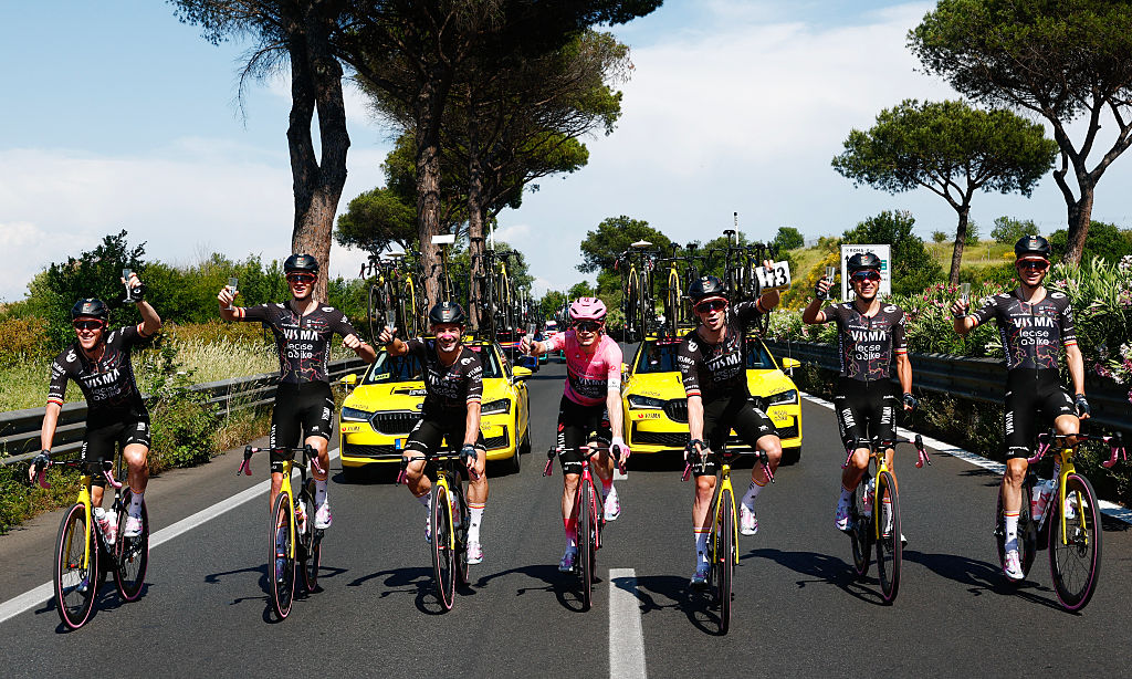 Team Visma Lease a Bike Danish rider Jonas Vingegaard wearing the overall leader's pink jersey holds a glass of sparkling wine with his teammates during the 21th stage of the Giro d'Italia 2026 - Tour of Italy cycling race of 131km from Rome to Rome, Italy, on May 31, 2026. (Photo by Luca Bettini / AFP)