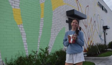 Muralist transforming white wall into huge painting at Block 59