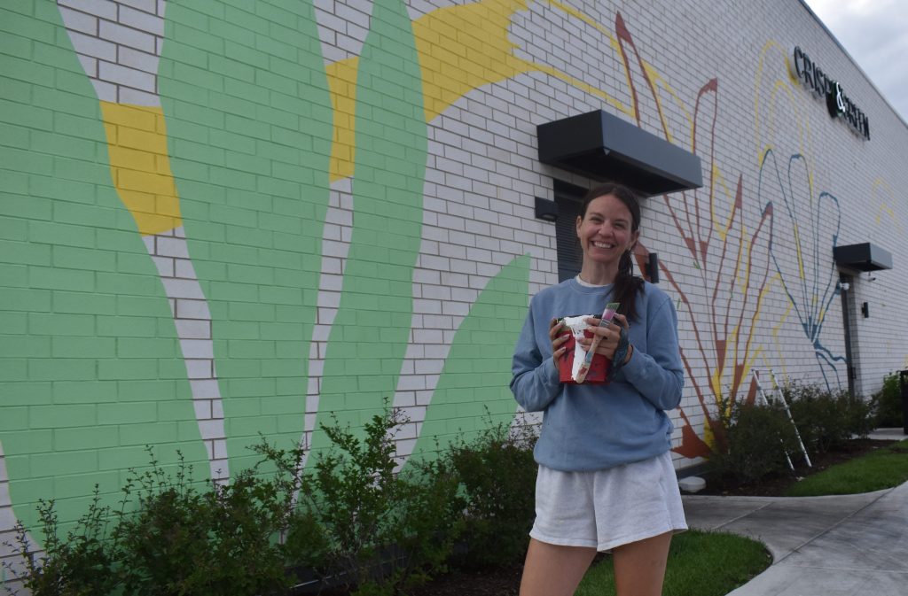 Muralist transforming white wall into huge painting at Block 59
