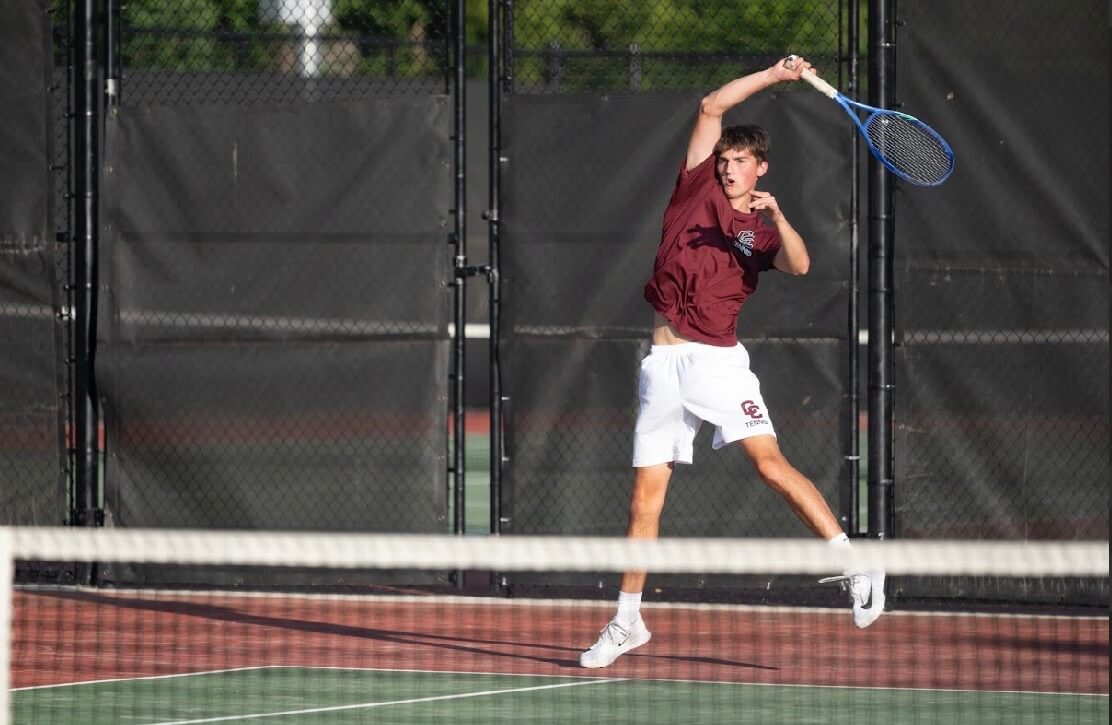 The Patriots’ Brooks Miller delivers a return playing first doubles against Lexington on June 4. Photo by Alexis Guinebertiere