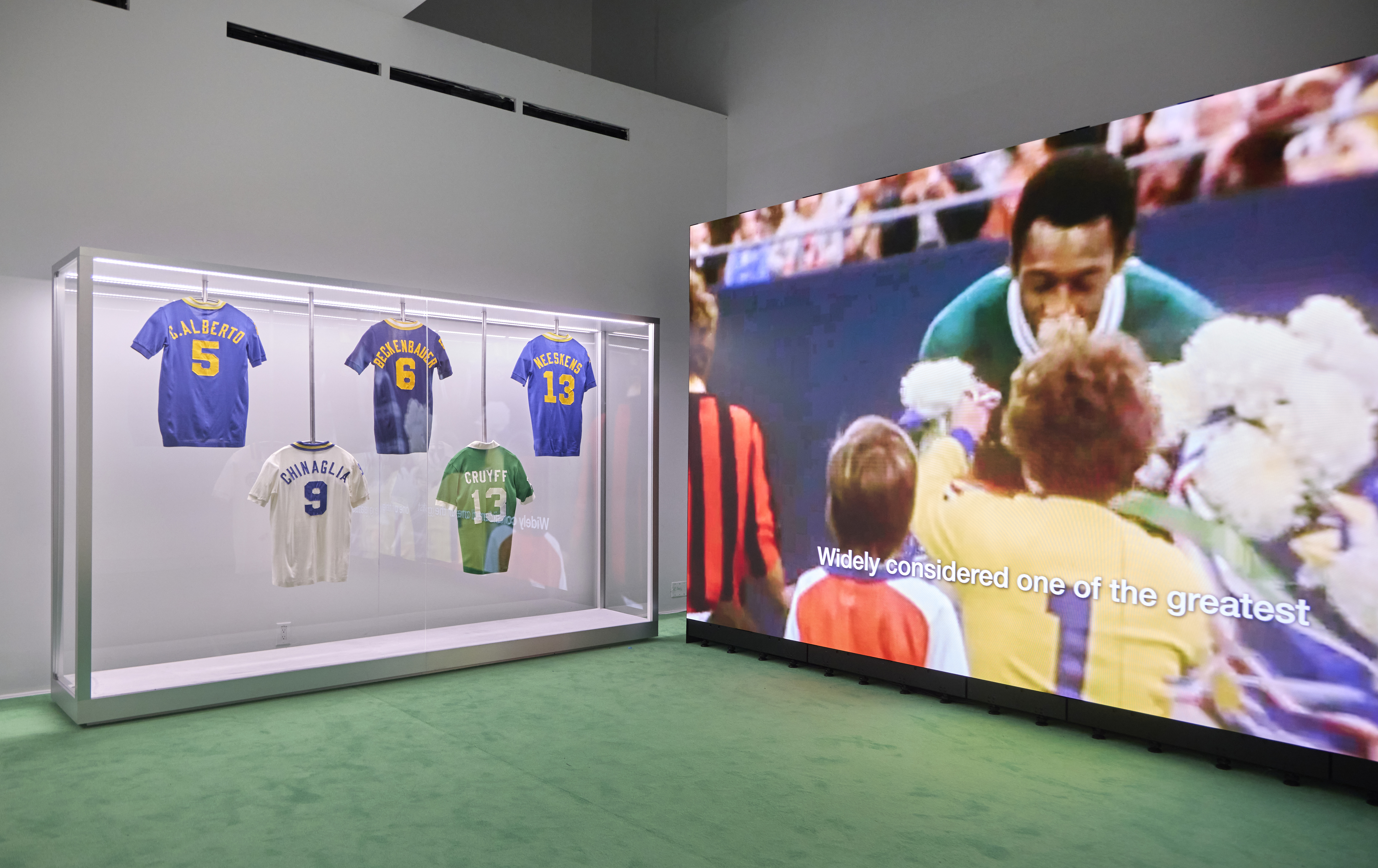 Football jerseys on display beside video installation at Home of Football: Home &amp; Away
