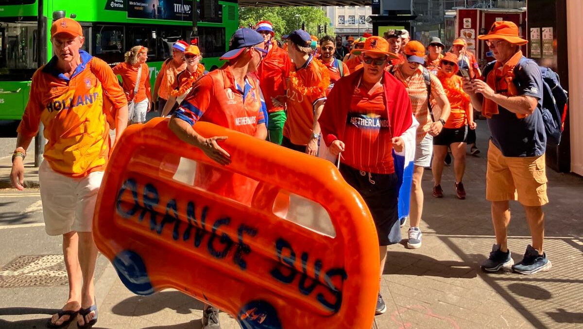 An orange bus dinghy leads march in Bristol for women's cricket