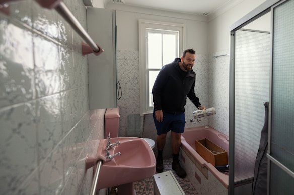 Alexander Symes in the existing pink bathroom.
