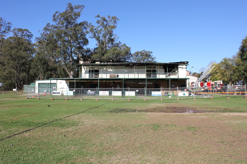 a burnt-out two story building surrounded by fencing