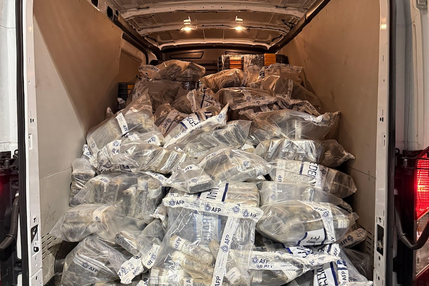 A large amount of packaged drugs inside the boot of a van, up to the vehicle's ceiling.