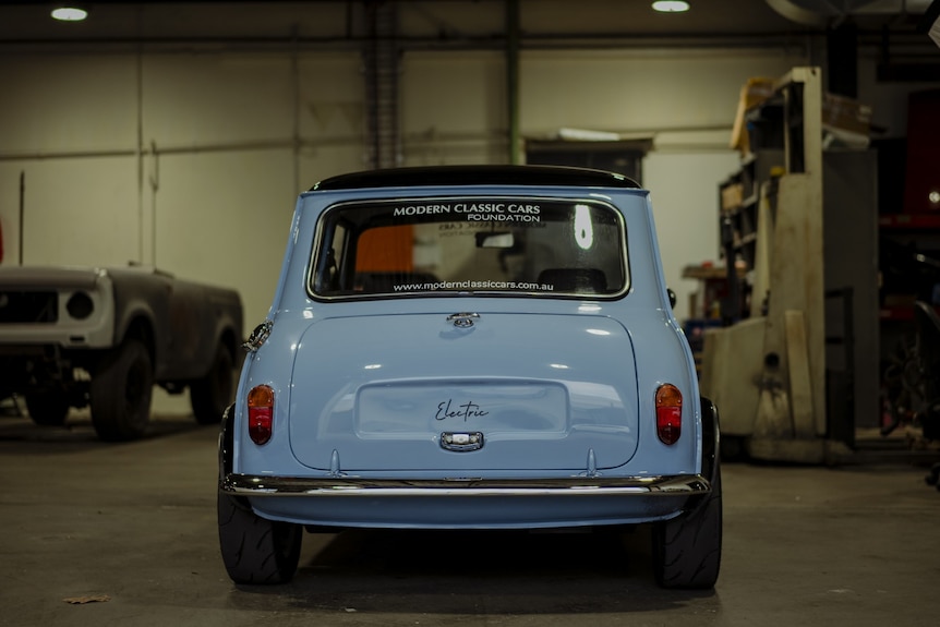 Back of small blue car with "electric" written on boot