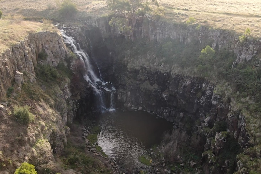 An overhead aerial image of a waterfall and full basin
