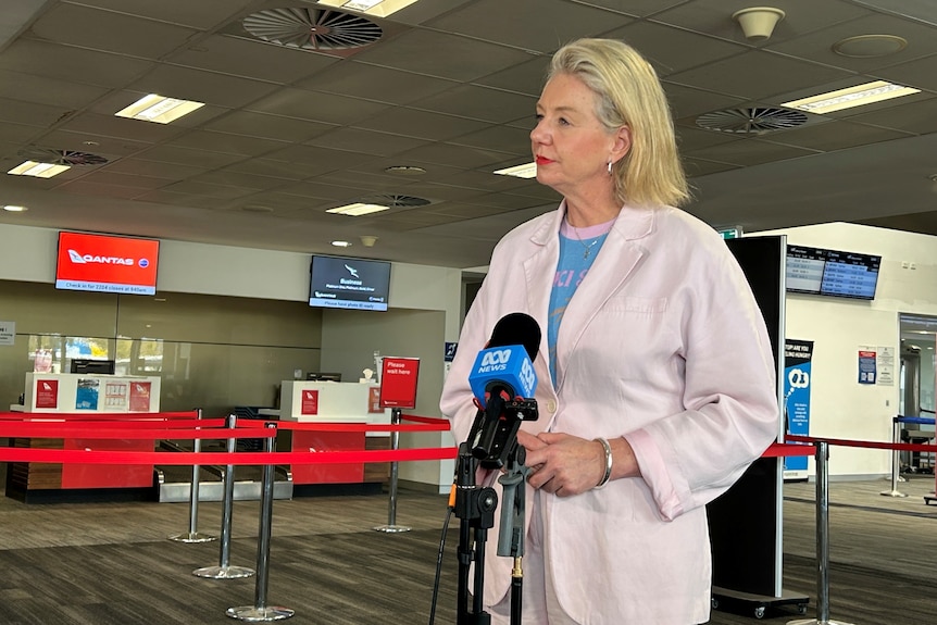 A woman speaks inside an airport.