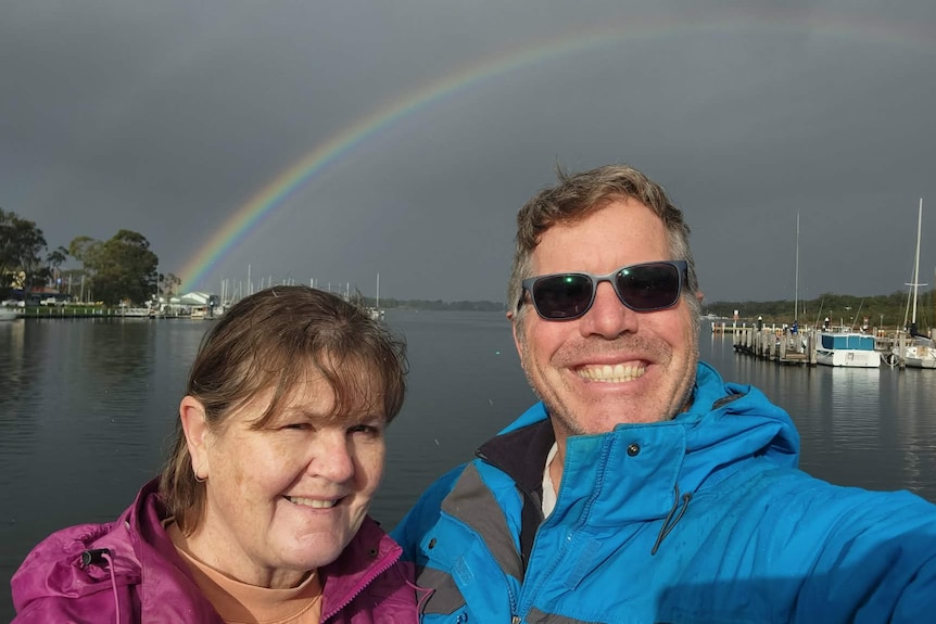 A photo of a woman wearing a purple jacket, next to a man with sunglasses and a blue jacket, in Gippsland Lakes