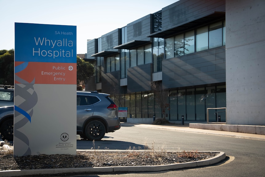 A blue, orange and white sign out the front of Whyalla Hospital emergency entry.