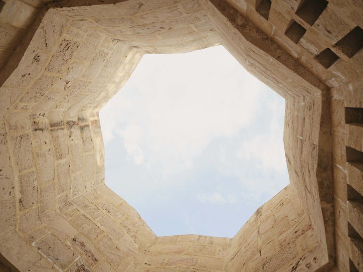 A distinct octagonal opening in the ceiling allows the simple brickwork to react to sunlight and colour.