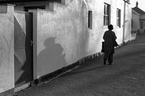 A woman out walking in North Carlton, Melbourne, is dwarfed by her shadow, 1979.
