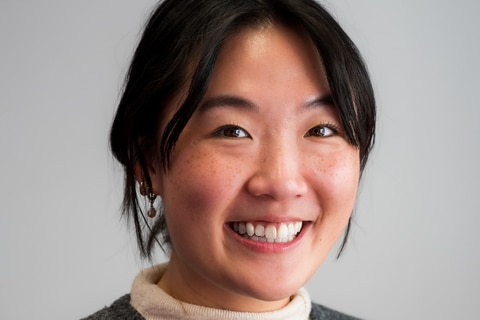 A woman with black hair smiles.