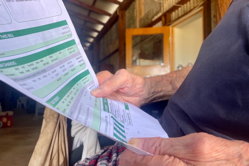 A man's hands holding an electricity bill.